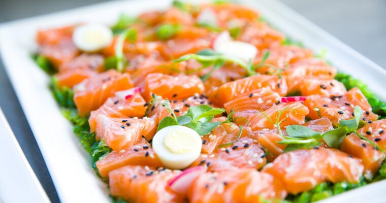 salmon with greens and quail eggs on banquet table